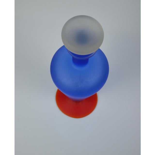 Striking sculptural decorative bottle in hand-blown frosted art glass, featuring a bold cobalt blue gradient body resting...