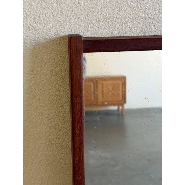 Authentic vintage Danish modern wall mirror crafted from solid teak, showcasing clean Scandinavian lines and warm natural...