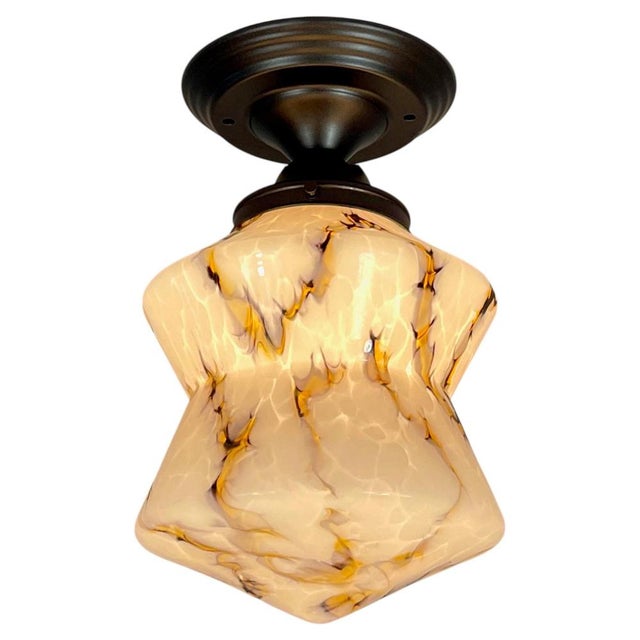 This Art Deco flush mount was designed any manufactured in Germany in the 1930s. The light features a sculptural marbled...