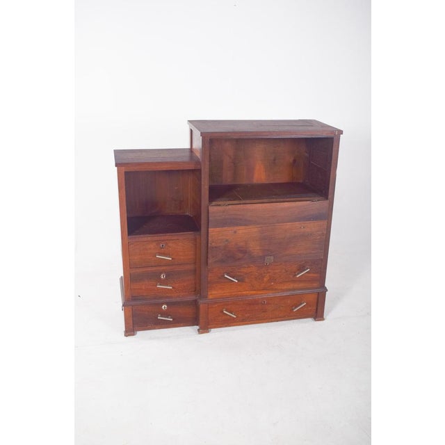 Tall, antique cabinet. With straight lines, it has a functional and utilitarian design, probably from the 20th century and...