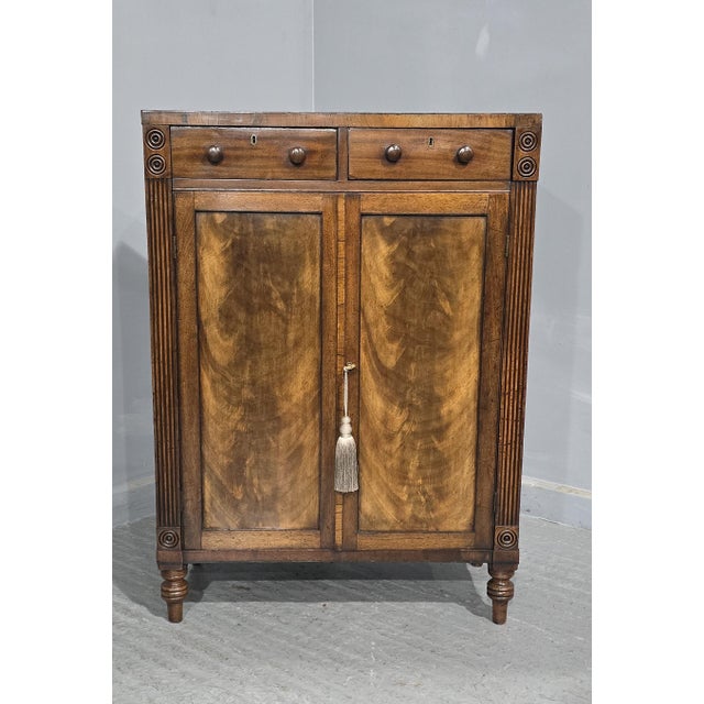 An excellent quaity Regency mahogany two door side cabinet of small proportions, with two drawers above, reeded sides with...