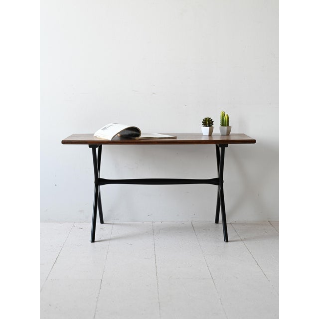 Scandinavian 1960s coffee table with rectangular teak top and X-shaped legs in black painted wood. Thanks to its modern...