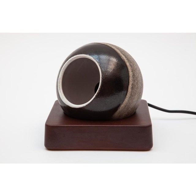 Modern 1970s brown and white glazed ceramic table lamp consisting of a square ceramic base on which the ceramic globe with...