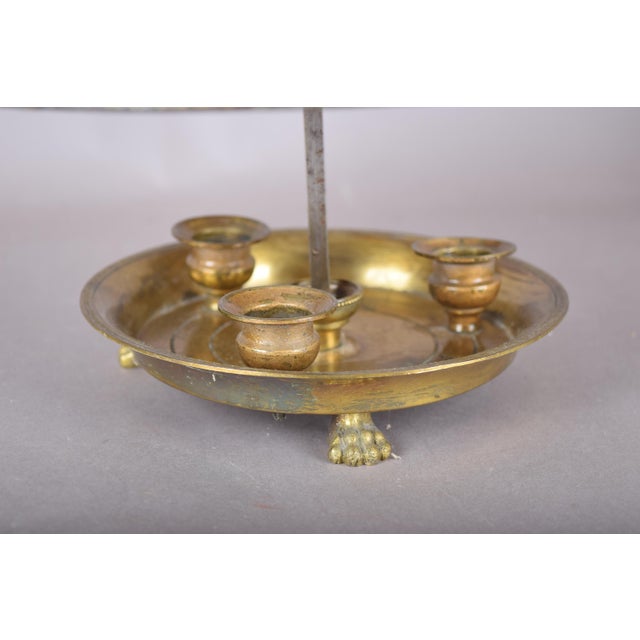 Brass bouillotte candle lamp with four candle holders in a round dished base on sculpted paw feet. Its included deep green...