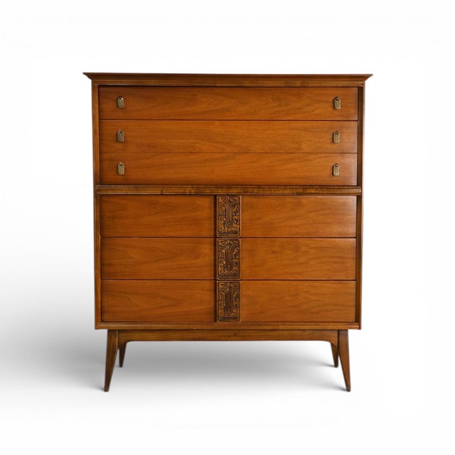 This 1960s Mid Century Modern Bassett Mayan highboy dresser is a distinctive example of American MCM design that balances...