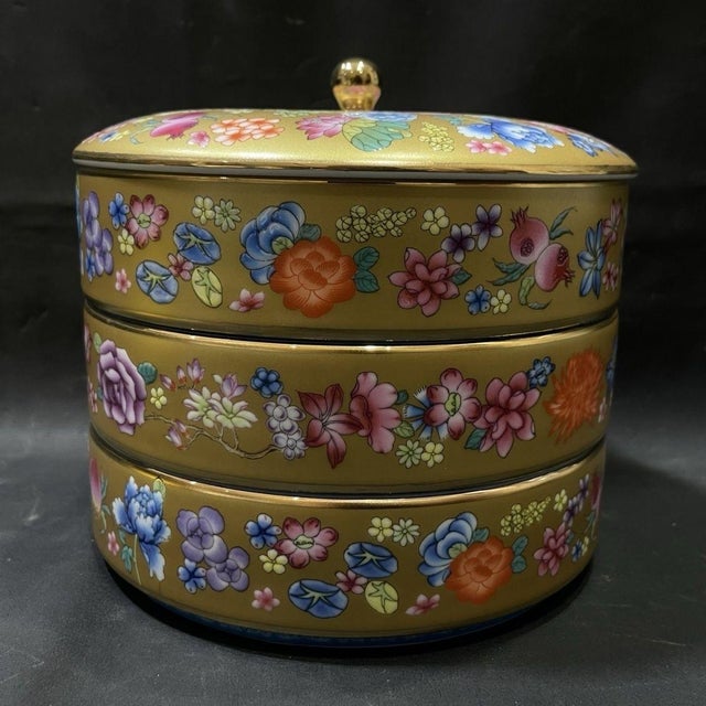 This is a vibrant and exquisitely decorated porcelain lidded jar, featuring intricate hand-painted floral motifs in the...