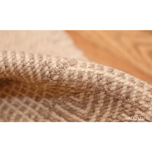 Woven circa 1950, this elegant vintage rug from Morocco features a series of geometric repeating motifs rendered in a chic...