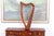 A small carved wooden Celtic 19-string table-top harp with a curved neck decorated in intricate knot work patterns and a...