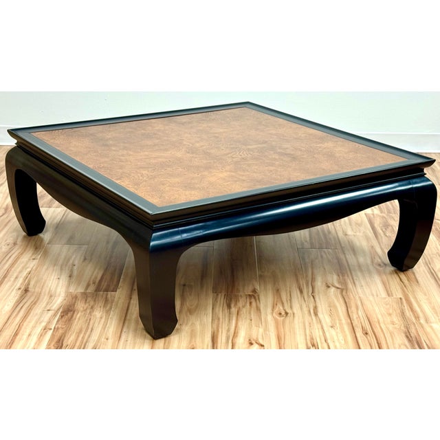 Classic Mid Century Asian wood coffee table with burled patchwork inlay to top and painted black frame and Ming legs....