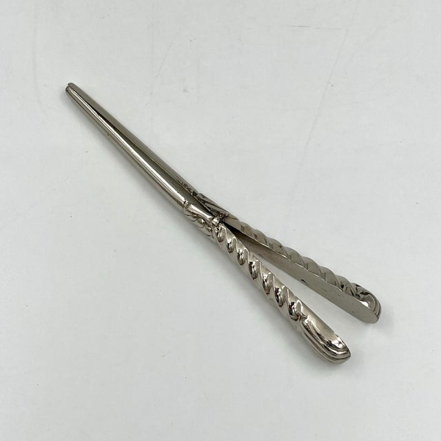 Vintage silverplate glove stretcher tongs with detailed scalloped and swirled handle. These vintage silverplate tongs were...