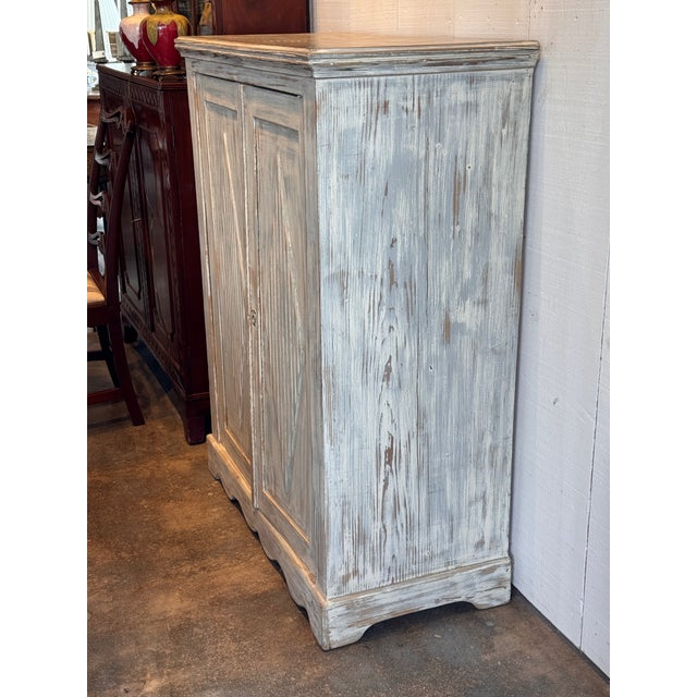Vintage Swedish painted cabinet with two paneled doors, each centered by a raised diamond motif with vertical carving. The...