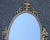 Large Adams style oval, ornate mirror with urn decoration on top, sphynx on each side and scrolling accents. Frame seems...