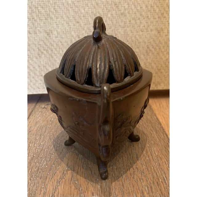 Antique bronze incense holder with a rustic European motif. The object is in the shape of a taurine with a decorative...