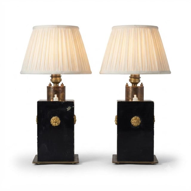 Pair of Art Deco-style table lamps dating to the 1940s. Rectangular black lacquered metal bodies sit above square brass...