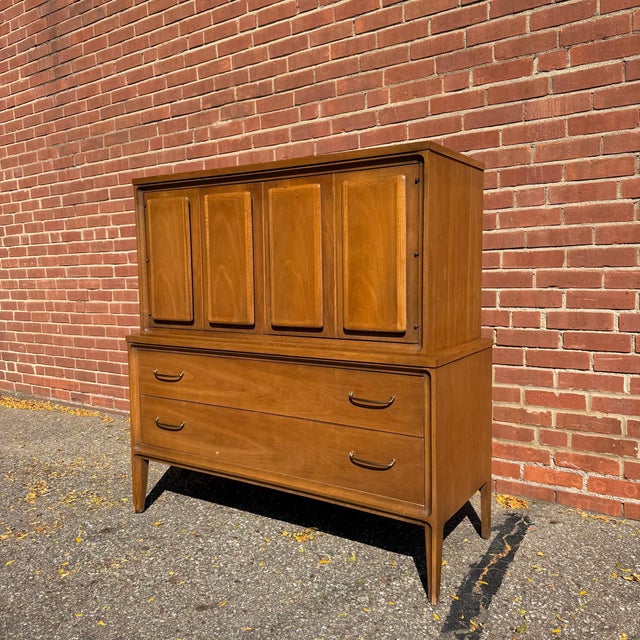 Vintage mid-century modern gentleman’s chest from Broyhill’s Forward collection. The upper cabinet has four paneled doors...