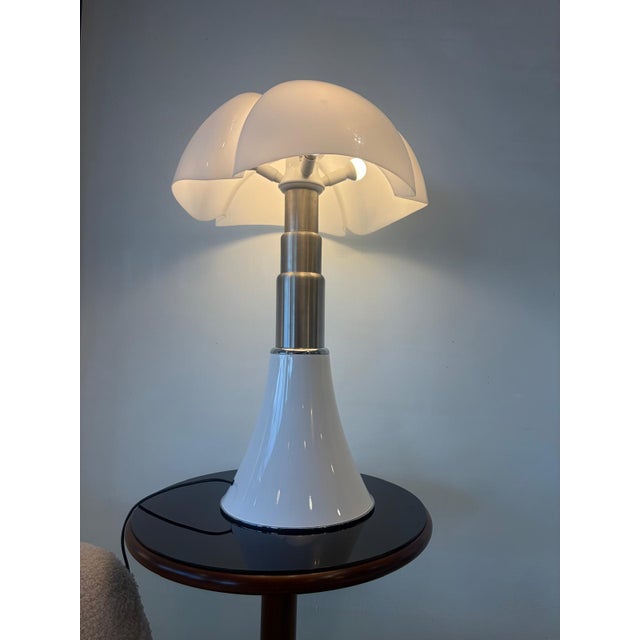 This iconic medium-sized table lamp from the celebrated Pipistrello series, designed in 1965 by Gae Aulenti for Martinelli...