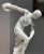 A handsome hand-carved alabaster esque sculpture of an Olympian athlete preparing to hurl a disc, probably 20th century....