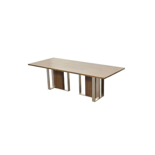 Trovata dining table made from Black Limba and American Walnut. The pedestals are supported by polished nickel metal base....