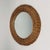 This vintage wall mirror was designed and manufactured in France in the 1950s. It features a hand woven rattan round frame...