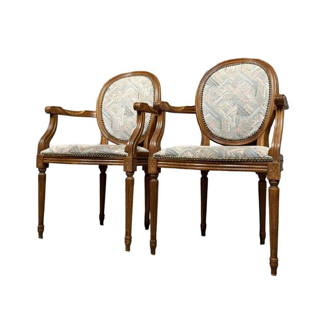 Pair of Louis XVI style armchairs with medallion backs. Cherry wood frame. Attractive modernist upholstery. Fluted legs....