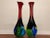 Pair of large, tall blown glass vases with long necks and very vibrant colors. They are wide at the bottom, not bulbous...