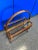 Mid Century modern rattan magazine rack in rich brown with lighter woven accents.