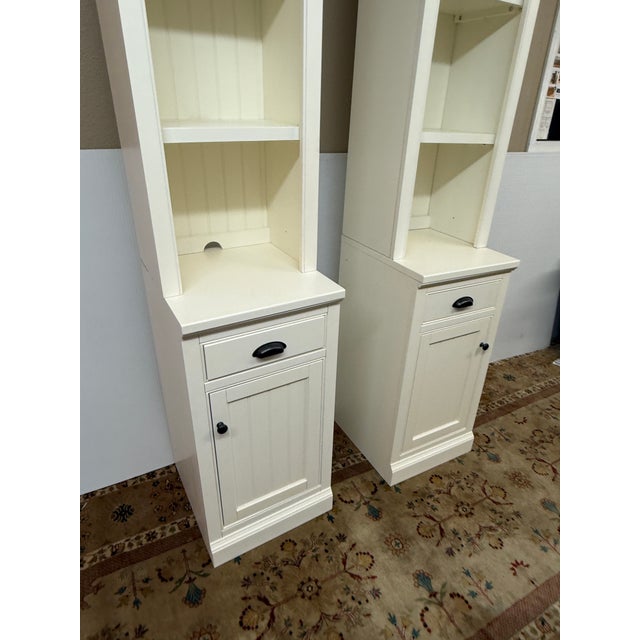 Design Plus Gallery presents a Pair of Dutch White Aubrey Narrow Storage Shelves with Cabinets from Pottery Barn. There is...