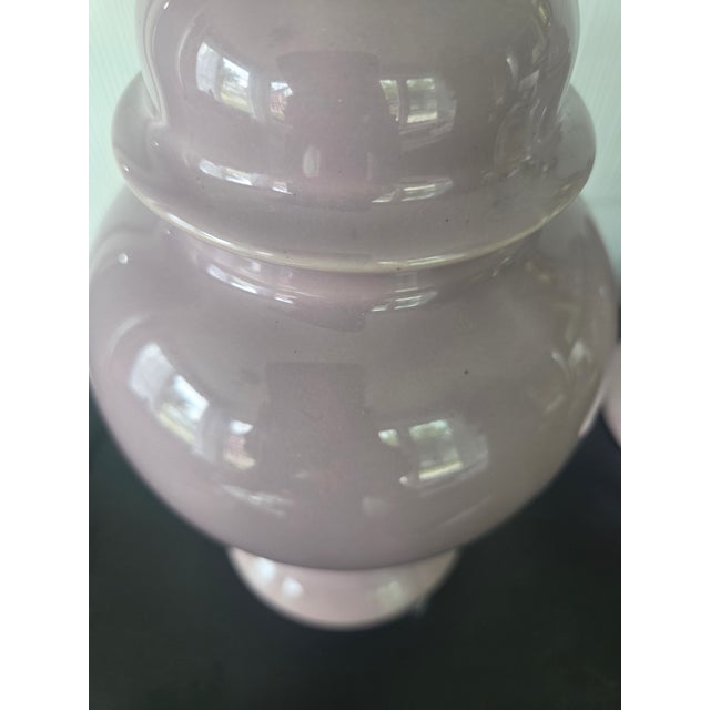 A matching pair of vintage ceramic table lamps. They feature a ginger jar style silhouette finished in a glossy lavender...