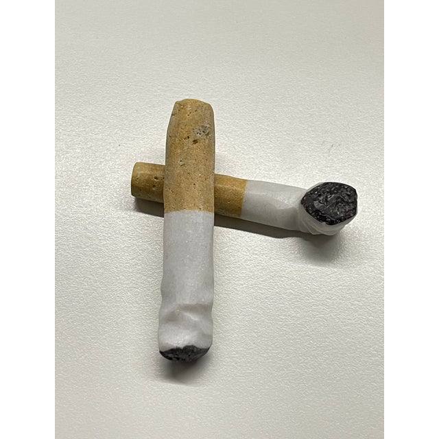2 sculptures crafted as faux smoked cigarette butts, expertly hand-carved from authentic Carrara marble. Extremely rare...