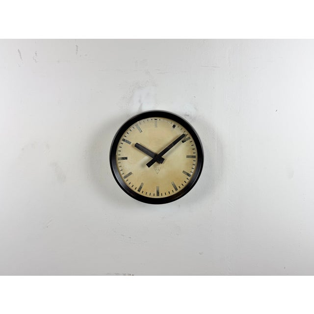 This wall clock was produced by Pragotron in former Czechoslovakia during the 1960s. It features a brown bakelite frame,...