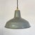 A pressed steel shade finished in grey vitreous enamel over a white enamelled interior, with a rolled rim and a tall...