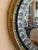 Round convex mirror with a circular gilt surround and an inset border of raised mirrored roundels set within a darker...