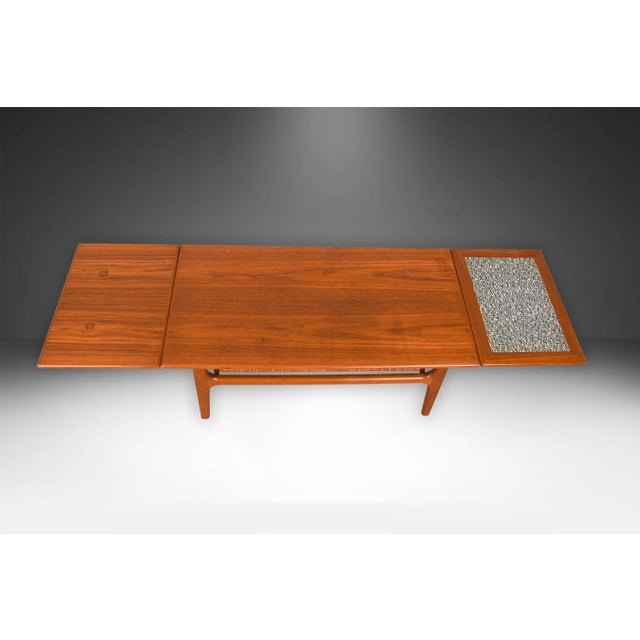 A beautiful, Danish, extendable two-tier design mid-century modern teak and cane coffee table manufactured in Denmark...