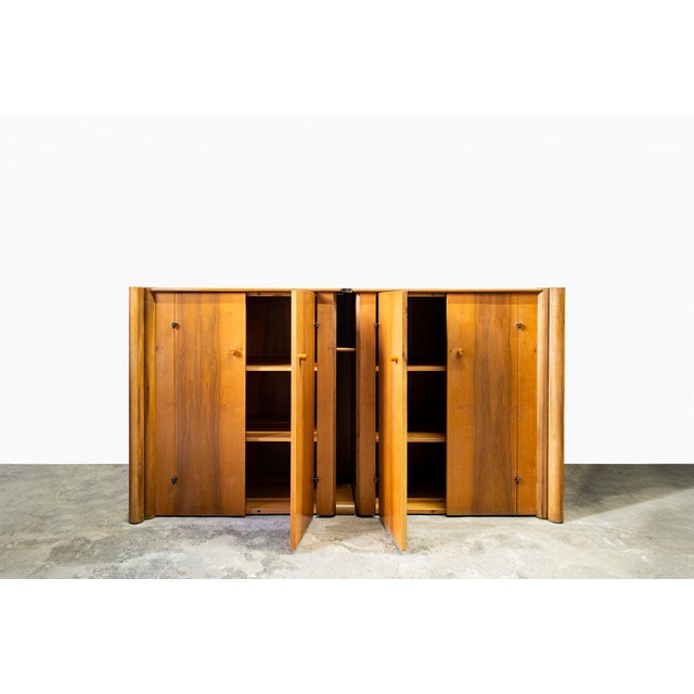 Horizontal four-door walnut sideboard. Designed by Carlo Scarpa Manufacturer: Bernini Year: 1977 This piece has an...