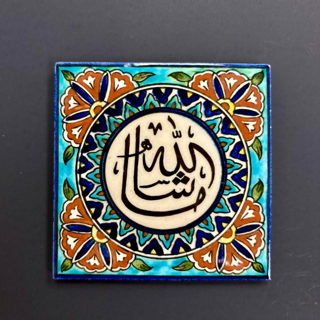 Discover the timeless beauty of this handcrafted Turkish ceramic tile featuring elegant Islamic calligraphy reading “Allah...