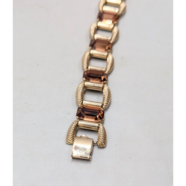1950s goldtone textured links with emerald cut faux-topaz bracelet with fold over clasp. Marked "NAPIER" on the back of...