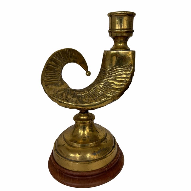 Vntage brass ram's horn candlestick, often associated with Hollywood Regency style. It features a distinctive curved,...
