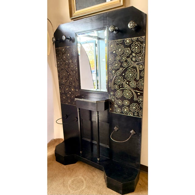 Striking Italian coat rack designed by Vittorio Zecchin, featuring a dramatic black lacquered finish with elaborate gilt-...