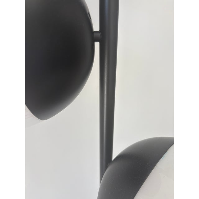 Wonderful subtle funk . The lamp has 3 lights white glass shades and black metal work. Plus a white marble base Very well...