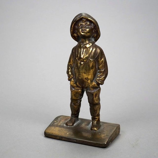 An antique pair of figural bookends offer bronzed cast metal sculpture of young boy street urchin, c1920 Measures- 7''H x...