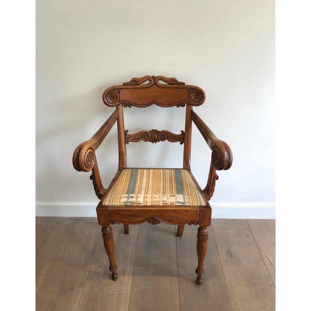 This very fine and elegant desk chair with swan neck decorations is made of carved wood. It is an English work from the...