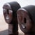 A pair of carved wood bookends from Haiti, circa 1960, each fashioned as a stylized figural head with an elongated crown...