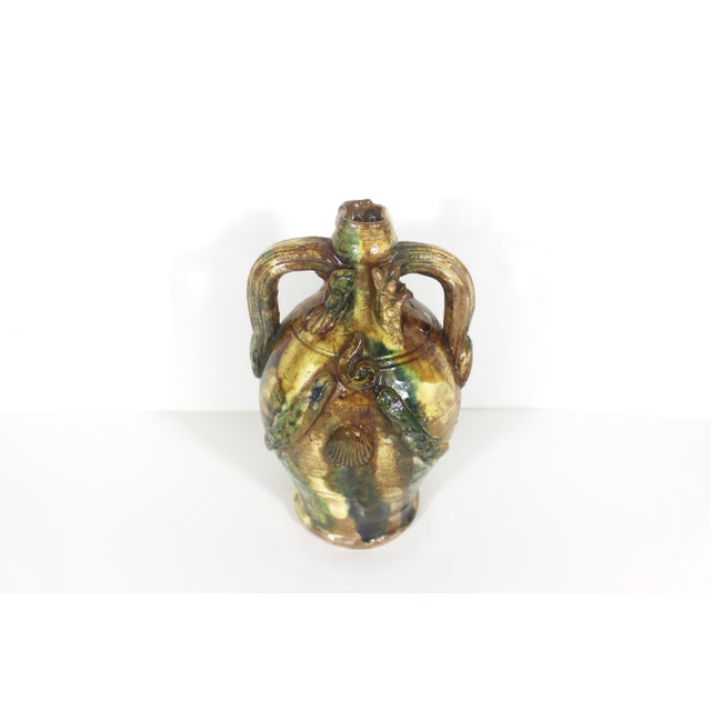 Absolutely stunning and unique folk art pottery vessel or vase with handles. This kind of looks like it was found at the...