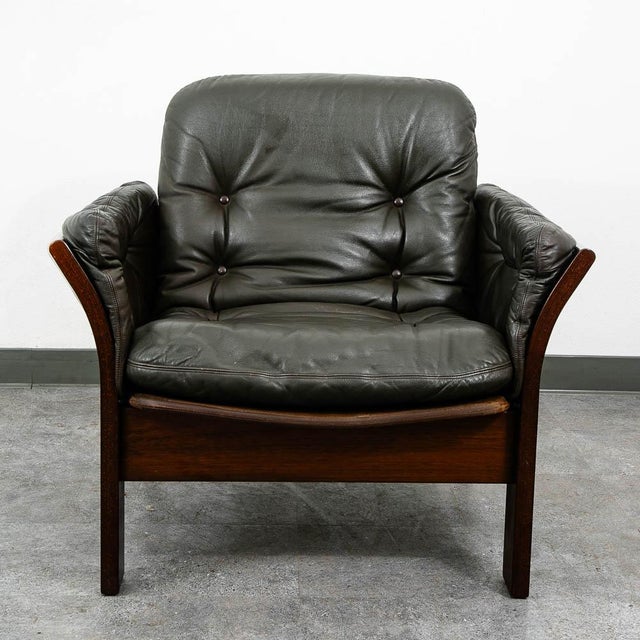 Dark brown leather lounge chair with a solid wood frame. Marked "Ryg Back Lehne" on the back of the cushion. A high-...