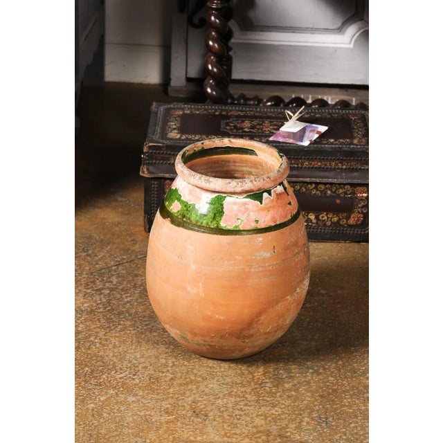 A French Provincial Biot jar from the 20th century with green glaze, generous lines and great weathered patina. Infuse...