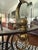 Vintage Hollywood Regency style round glass dining table with sculptural dolphin/koi fish accents, brass-tone details,...