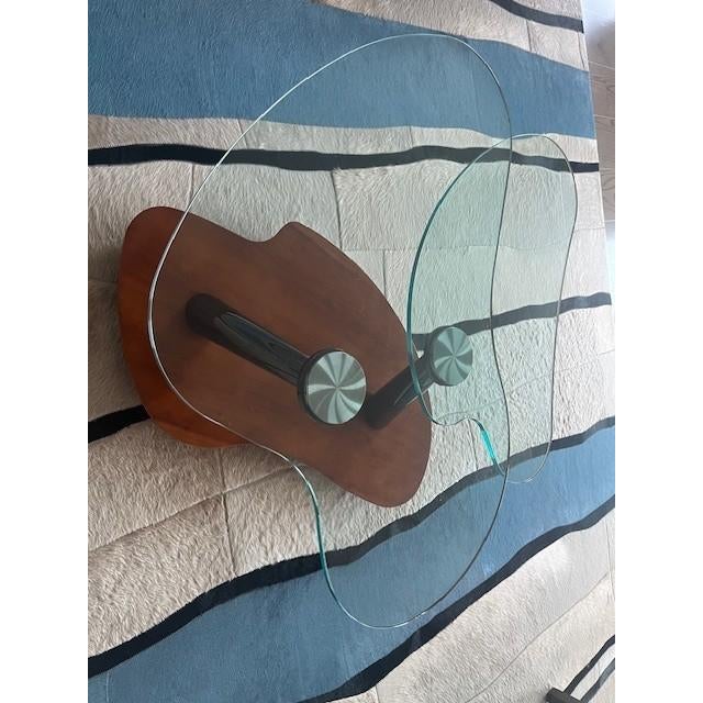 Elegant coffee table features two synchronized swivel tops supoorted by polished chrome supports on a polished walnut base.