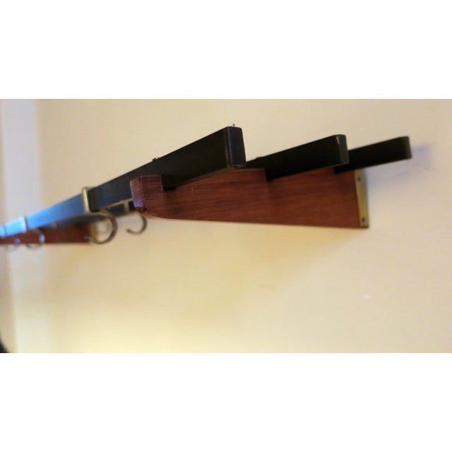 Teak, brass and metal wall mounted coat and hat rack dating from the 1960s, with 7 adjustable sliding hooks.