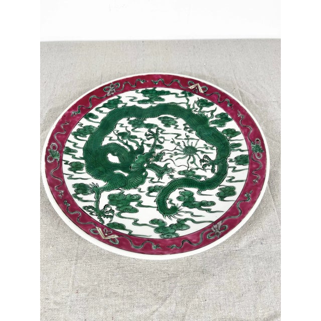 Vintage chinoiserie dragon plate. Green dragon design with raspberry/burgundy trim. Signed on back.