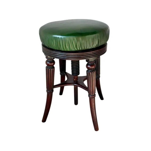 Victorian Adjustable Mahogany Music Stool. Stool is crafted in rich mahogany and features an aged dark green leather...